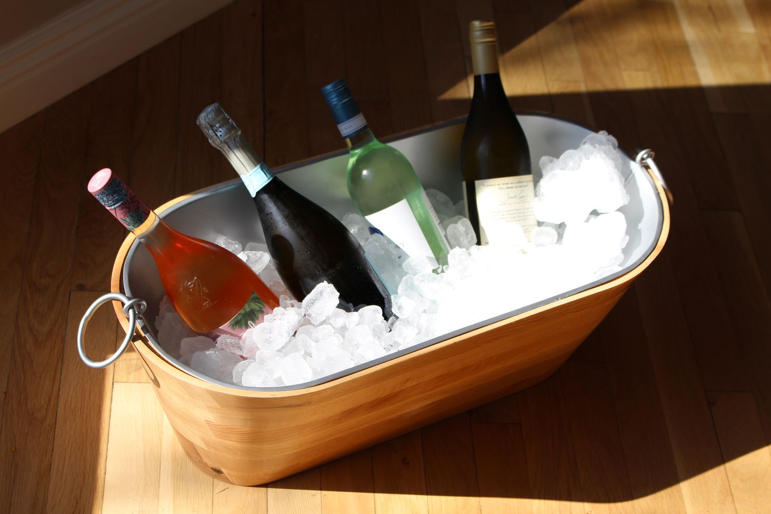 A chilled bottle of nonalcoholic white wine resting in an ice bucket beside a set dinner table