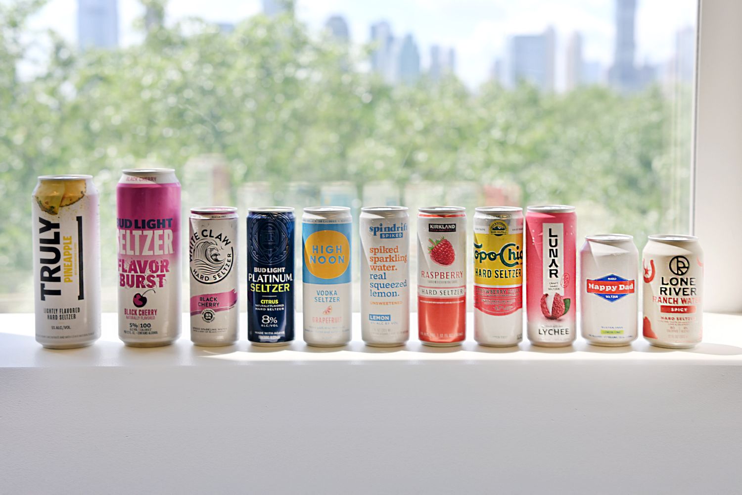 A cold hard seltzer can with condensation on a patio table next to a glass filled with ice