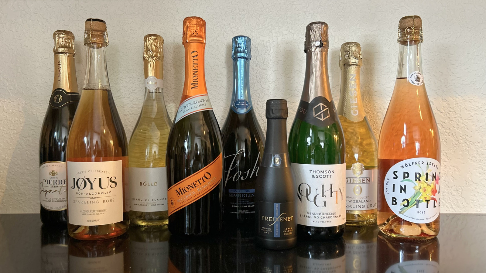 A cozy wine bar counter with a chilled bottle of nonalcoholic sparkling wine in an ice bucket and two stemmed glasses, photographed in warm evening light