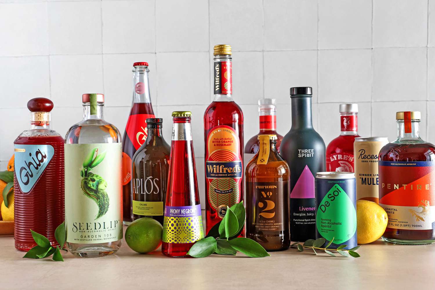 A restaurant backbar shelf displaying bottles of nonalcoholic spirits alongside syrups and bar tools, photographed in a real bar setting